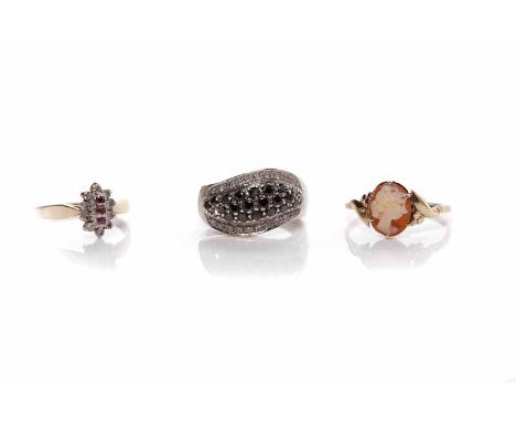 THREE GOLD DRESS RINGScomprising a black and white diamond set ring, a ruby and diamond cluster ring and a cameo set ring (3)