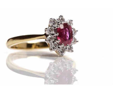 RUBY AND DIAMOND CLUSTER RING BY BOODLESthe central oval ruby measuring 6mm x 4.5mm, surrounded by a row of brilliant cut dia