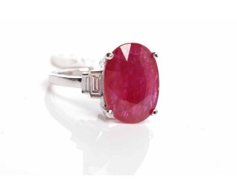 RUBY DRESS RINGset with a large oval ruby of approximately 8.22 carats flanked by two pairs of baguette cut diamonds, in eigh