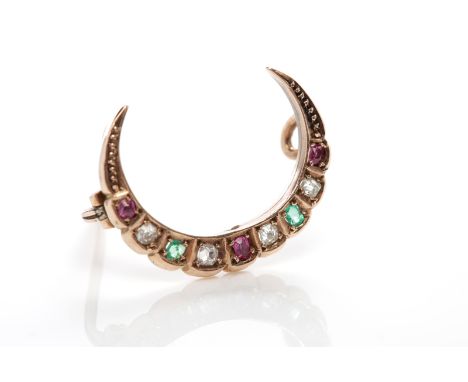 DIAMOND, RUBY AND EMERALD CRESCENT BROOCHc.1900, set with cushion cut stones, in nine carat gold, 22mm across