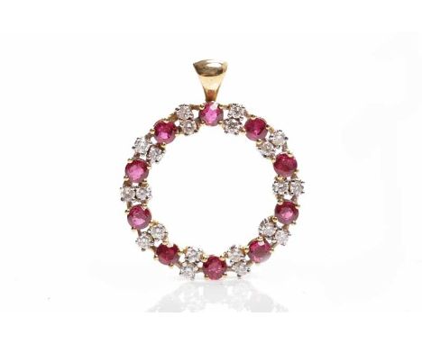 RUBY AND DIAMOND PENDANTof circular form, set with round rubies interspaced by pairs of diamonds, in eighteen carat gold