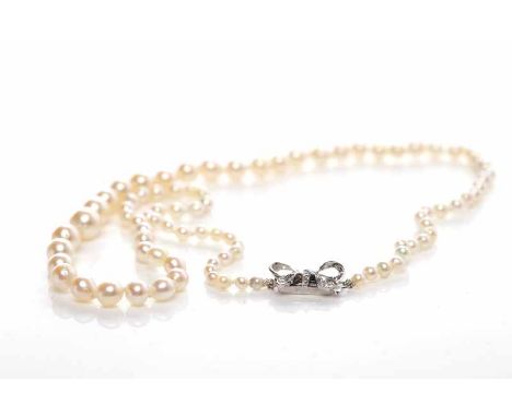 EARLY TWENTIETH CENTURY CULTURED PEARL NECKLACEwith graduated pearls, the bow motif clasp set with diamonds, 43cm long