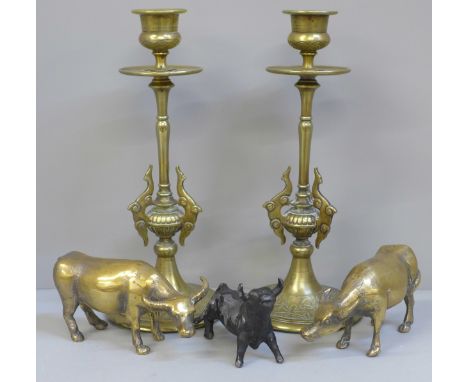 A pair of Indian brass candlesticks, two brass oxen and a metal model of a bull 
