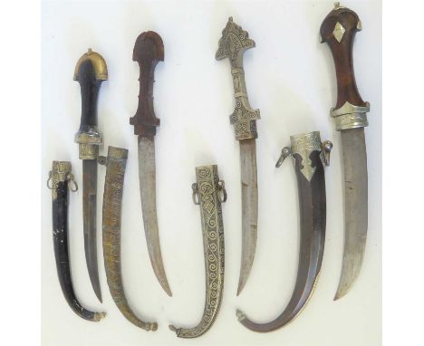 Four Caucasian Jambiyas, each with curved double edge steel blade, one with white metal hilt and scabbard incised with scroll