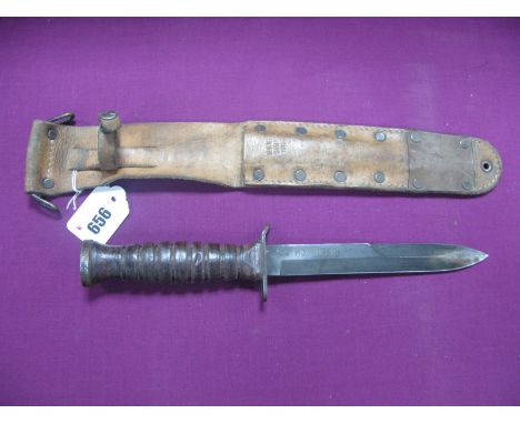 A WWI U.S. M3 Fighting Knife, dated 1943 on blade, light rust on tip of blade, in it's correct leather scabbard dated 1943.