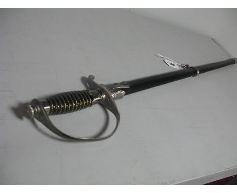 Replica Third Reich S.S Officers Dress Sword, in its black leather scabbard with white metal fittings.