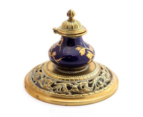 A late 19th Century brass ink stand with porcelain blue ground/gilt floral detail inkwell and brass lid, 16cms diameter appro
