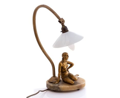 A 1930's Art Deco lady figure lamp, lady seated on an onyx base, gold finish, with white glass shade, wired with plug.Conditi