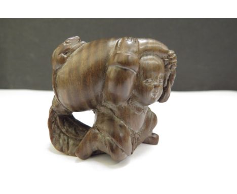 A Meiji period (1868-1912) Japanese wood Netsuke figure carrying a large root vegetable with mouse to top, signed 4cm x 4.5cm