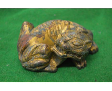 A Chinese gilded metal model of a recumbent lion.