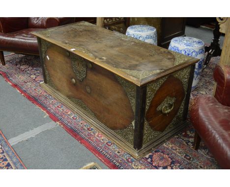 An eastern teak trunk with pierced brass decoration and brass carrying handles.