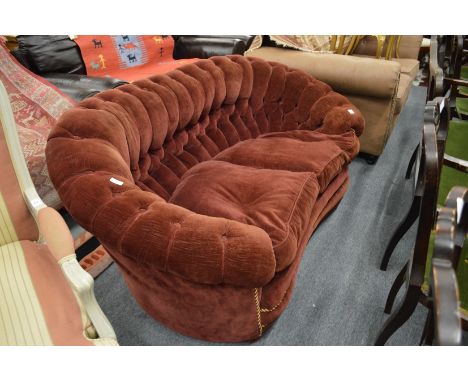 A button back, crimson upholstered two-seater settee.