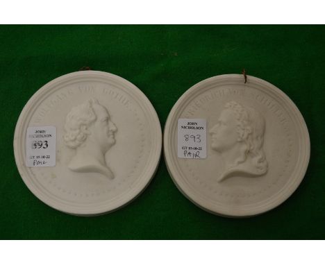 A pair of circular bisque porcelain portrait plaques.