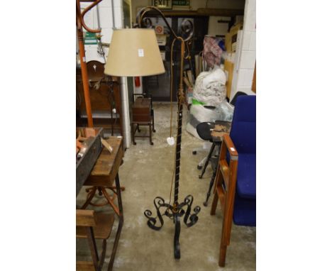 An ornate wrought iron and brass standard lamp.