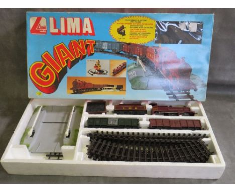 A BOXED LIMA O GAUGE BATTERY OPERATED STEAM LOCOMOTIVE, tender, wagons, track and level crossing