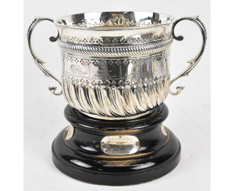 A Victorian hallmarked silver twin handled trophy, awarded to Robert Farrer in 1902 for the 'Best gold for three successful y
