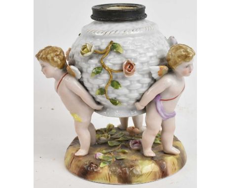 A Continental floral encrusted porcelain oil lamp base, modelled as three cherubs holding the well aloft, height 16cm.