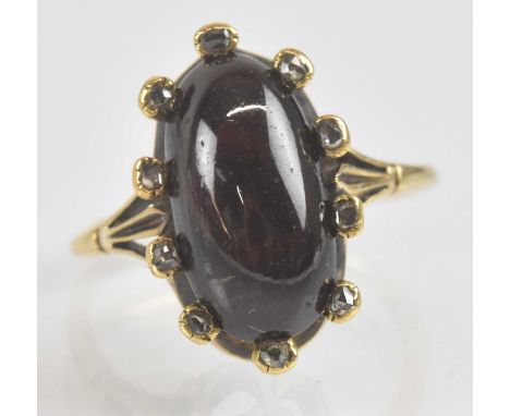 An Edwardian amethyst and diamond ring, the large oval amethyst cabochon held with ten tiny bezel set diamond chips on crown 