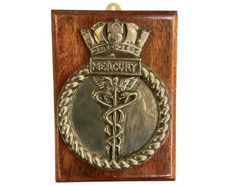 An early 20th century bronze boat badge, 1941 Shore Establishment 'HMS Mercury', mounted on wooden wall hanging plinth, 27 x 