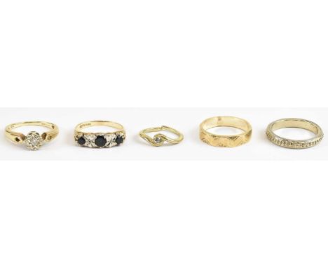 Five gold rings comprising a 9ct example with three sapphires and two illusion set white stones, size L, approx 2.2g, a white