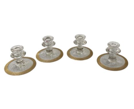 A set of four early 20th century cut glass crystal dwarf candlesticks, the short handblown holder on conical base with cut fl