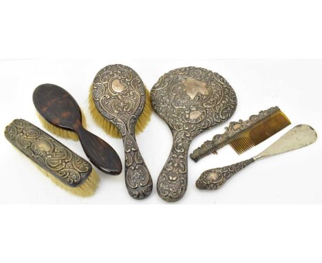 A five piece loaded silver backed dressing table set comprising hand mirror, hairbrush, partial comb, clothes brush and shoeh