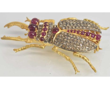A 925 hallmarked silver gilt brooch modelled as a stag beetle, set with multiple small diamonds and cabochon rubies, total di