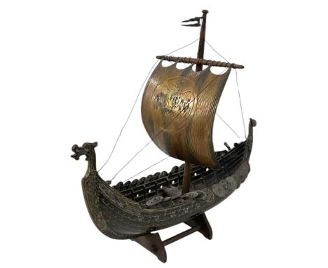 A modern bronze scratchbuilt model of a Viking sailing vessel, on carved wooden base, height 39cm, length 40cm.