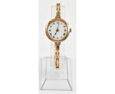 A lady's vintage 9ct gold wristwatch, the white enamel dial set with Roman numerals and gold dot outer track, with crown wind