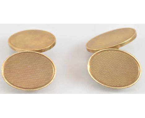 A pair of 9ct gold oval cufflinks, one face with engine turned decoration, united by chain, combined approx 14.4g.