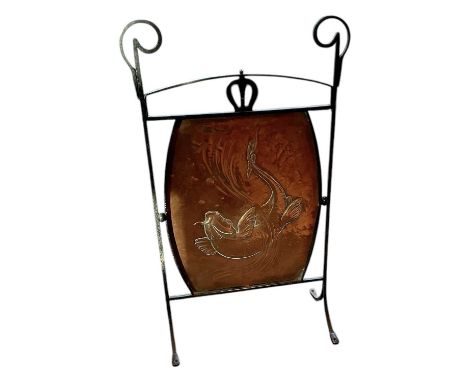 An early 20th century Arts and Crafts wrought iron framed firescreen, with copper panel insert depicting leaping carp, height