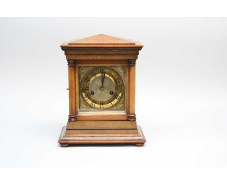 A small walnut cased mantle clock, with an embossed brass dial with Roman numerals, 30cm high, 15.5 x 24cm.