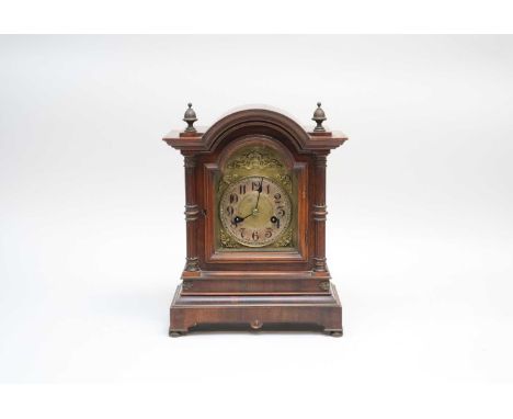 A 19th century mahogany cased mantle clock, with a brass and silvered dial with black Arabic numerals, in an architectural ca