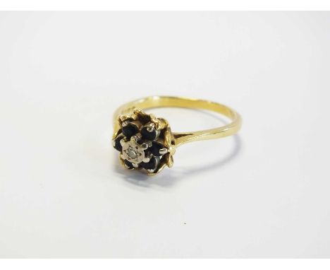 An 18ct gold sapphire and diamond ring, designed as a central eight cut diamond illusion set within a surround of six faceted