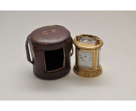A miniature cased brass carriage clock, of oval form, the white enamel dial with black Roman numerals, with bevelled plates, 