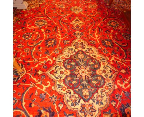 A fine central Persian Sarouk carpet 386 x 265cm central double pendant medallion with repeating spandrels on a terracotta fi