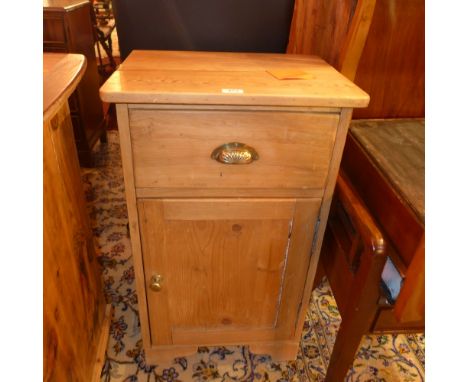 An Edwardian pine side cabinet with a single drawer over a cupboard door raised on bracket supports 