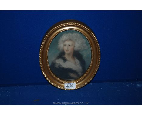 A gold frame oval portrait of a grey haired woman.
