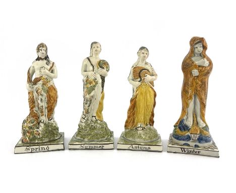 A set of four Prattware allegorical figure of the Seasons, circa 1800, each modelled as a Classical woman, sponge decorated, 