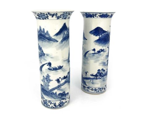 A pair of Chinese blue and white sleeve vases, Kangxi mark, painted in the round with extensive watery landscape with figures
