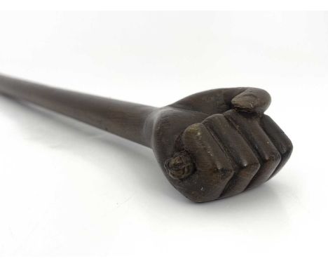 A treen door knocker, late 19th/early 20th Century, carved as a clasped hand, tapered shaft, 58cm long