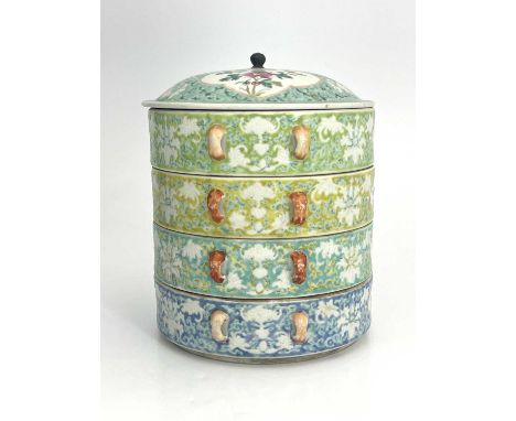 A Chinese famille rose stacking box, four sections of different coloured ground lotus and foliate scroll design with ogee car