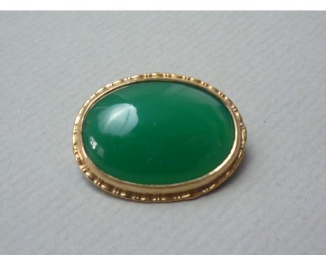 A jade brooch, the cabochon of approximately 2.3 cm x 1.6 cm, rub and rope set in 9ct gold