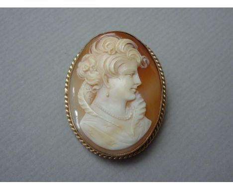 A shell cameo brooch, carved in depiction of a young lady wearing an Elizabethan collar and pearl jewellery, rub and rope set