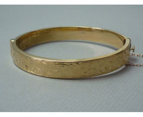 A 9ct gold hinged bangle, the face foliate engraved, 13g