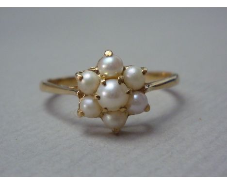 A pearl flowerhead cluster dress ring, claw set above an open gallery on a 9ct gold shank 