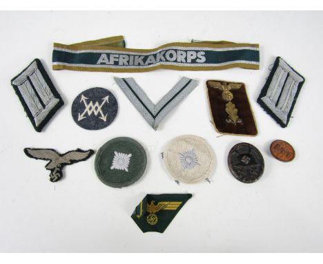 A group of German Third Reich insignia including an Afrikakorps cuff title, Army officers' litzen, NSDAP collar patch, black 