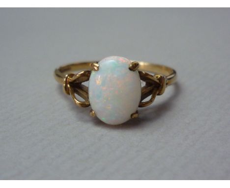 An opal dress ring, the cabochon of approximately 1.65ct, crown set and flanked by a bifurcated and looped shank, on 9ct gold