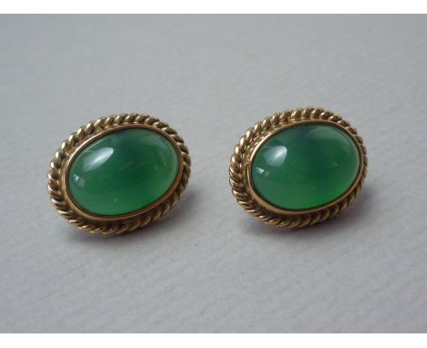 A pair of 9ct gold and jade stud earrings, the oval cabochons rub set within a rope twist frame