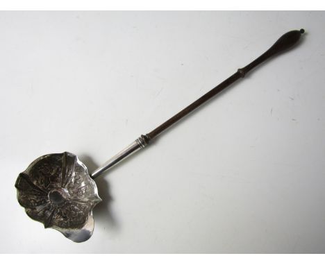 A George II white-metal punch ladle, the oval shaped bowl being lobed and repousse moulded in depiction of flowers and foliag